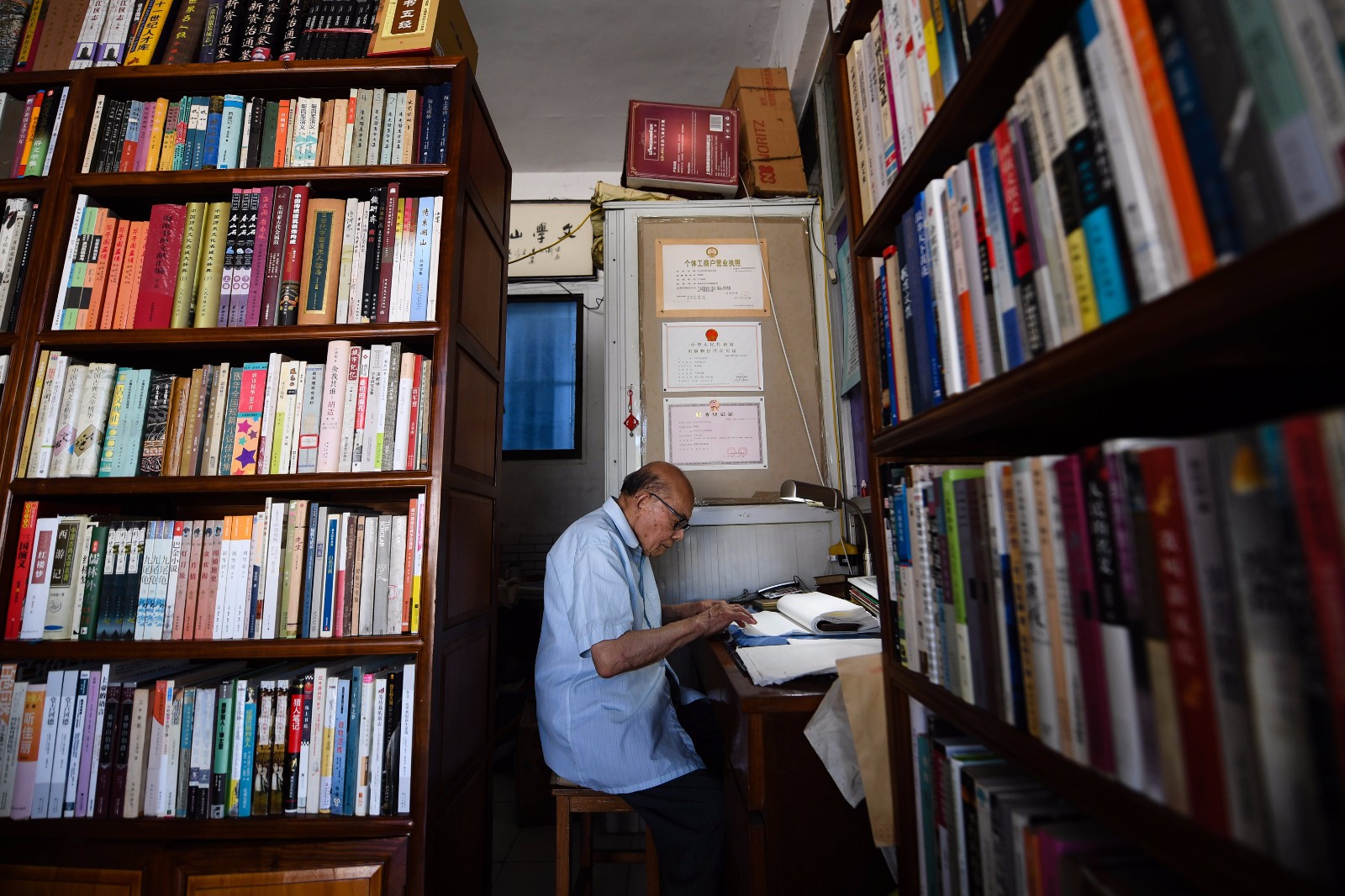     7月18日，江澄波老人在“文学山房”旧书店修补古书。 