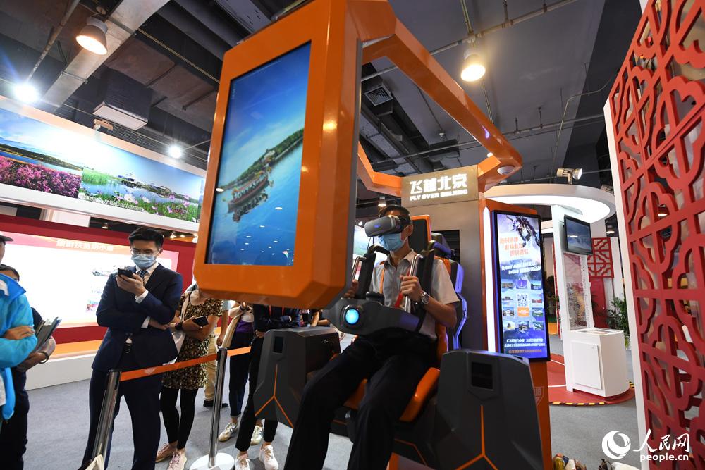 参观者正在体验飞越北京模拟飞行器。人民网记者翁奇羽摄